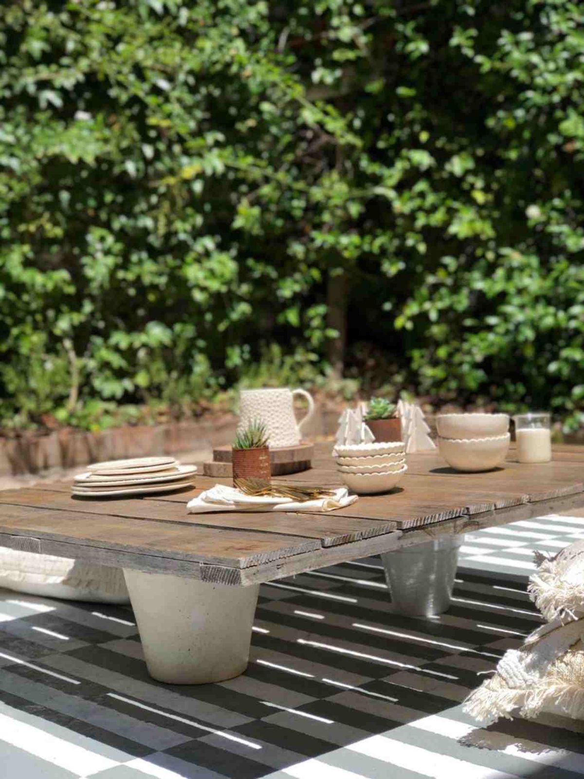 Mesa con tablas de madera y macetas.