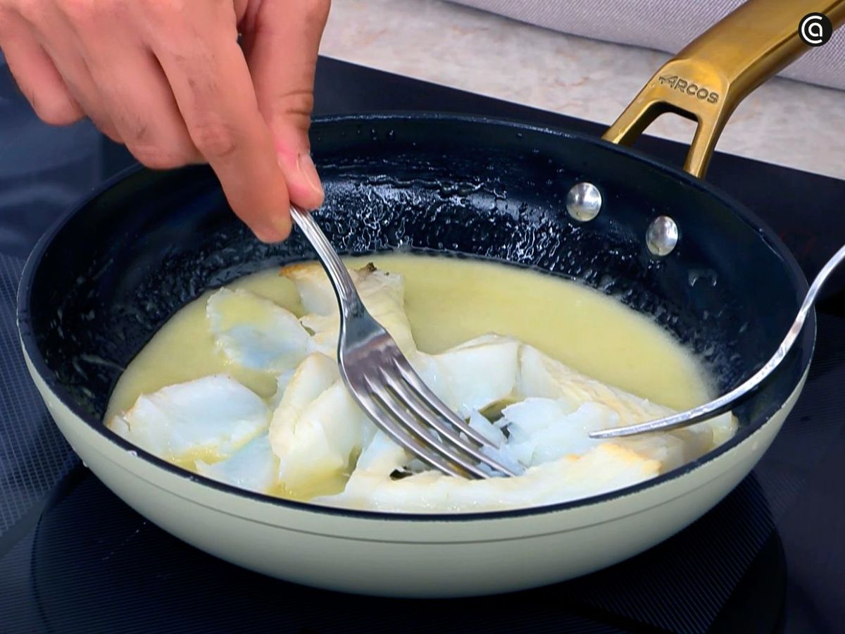 Separar las lascas del bacalao en la salsa pilpil