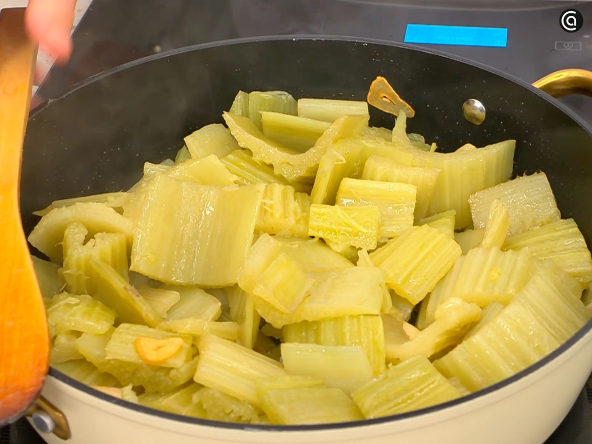 Dora unos ajos laminados y saltea con ellos el cardo cocido