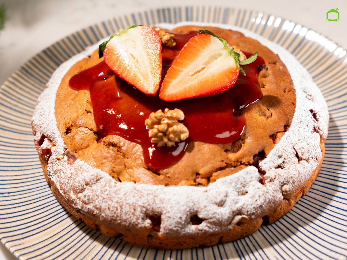Cubre el bizcocho con mermelada de fresa y espolvorea azúcar glas