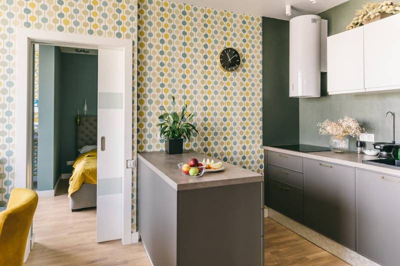 Cocina con papel pintado con estampado de círculos en color verde.