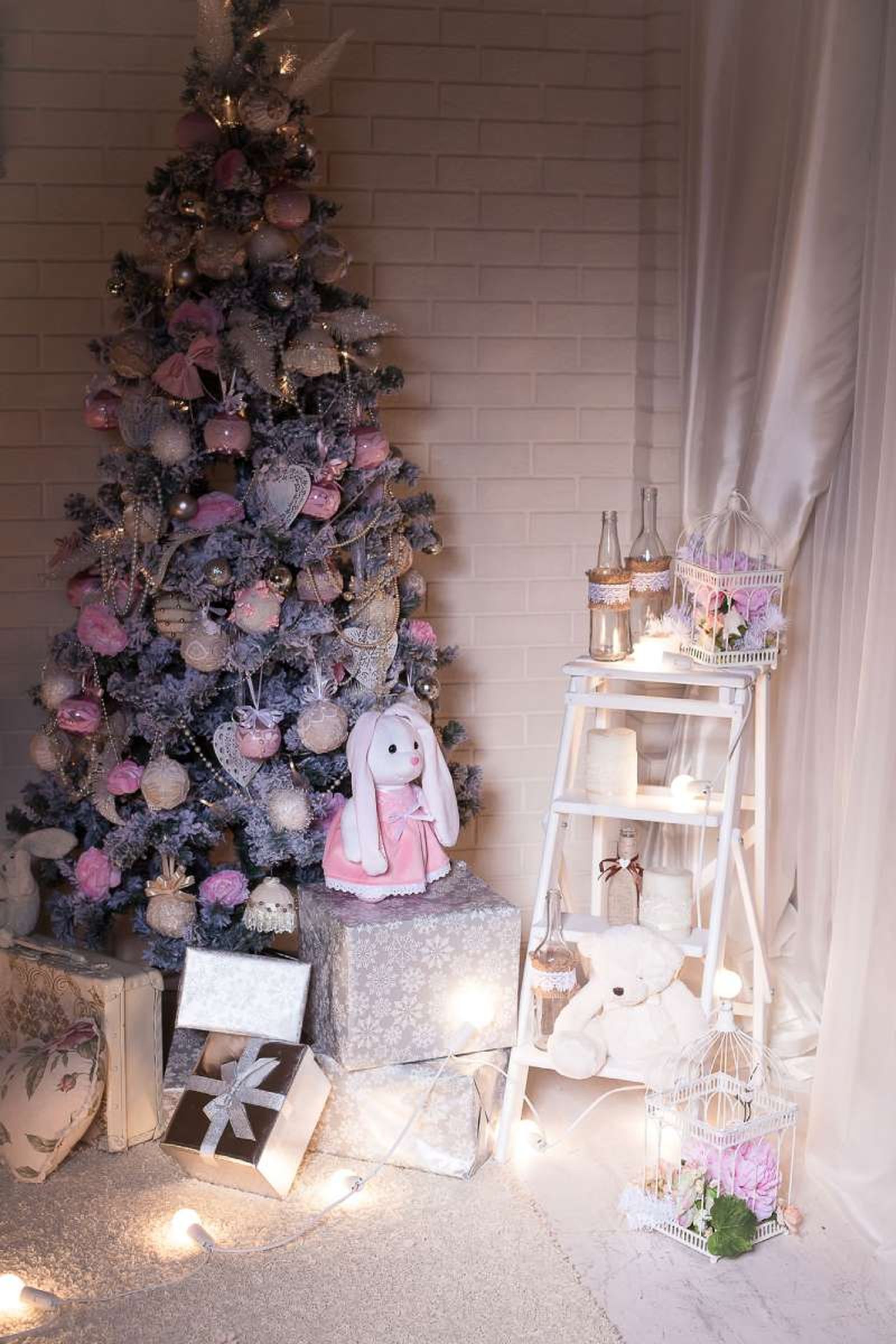 Árbol de Navidad con adornos rosa con el pie decorado con regalos. Árbol de Navidad con adornos rosa con el pie decorado con regalos.