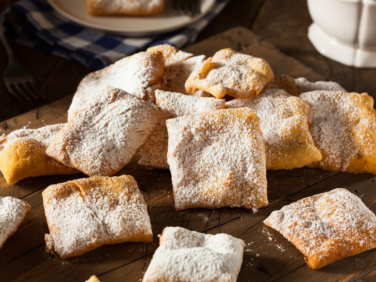 Beignets cubiertos de azúcar glas, el dulce frito más reconocible del Mardi Gras.