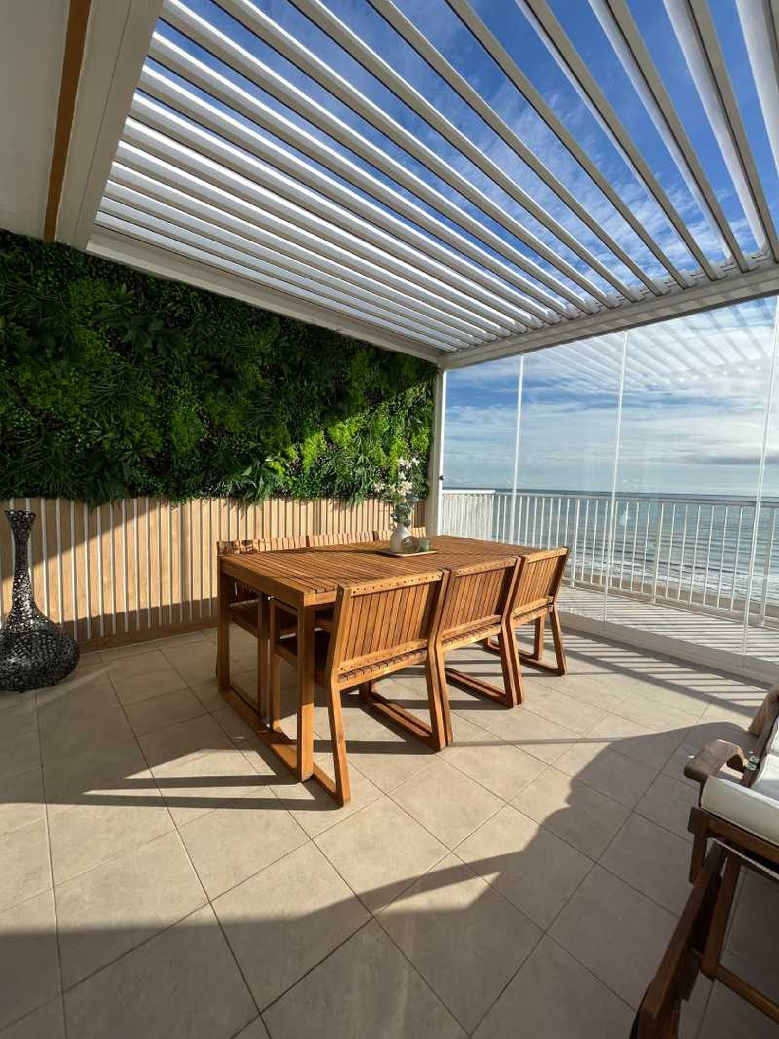Pérgola bioclimática con jardín vertical.