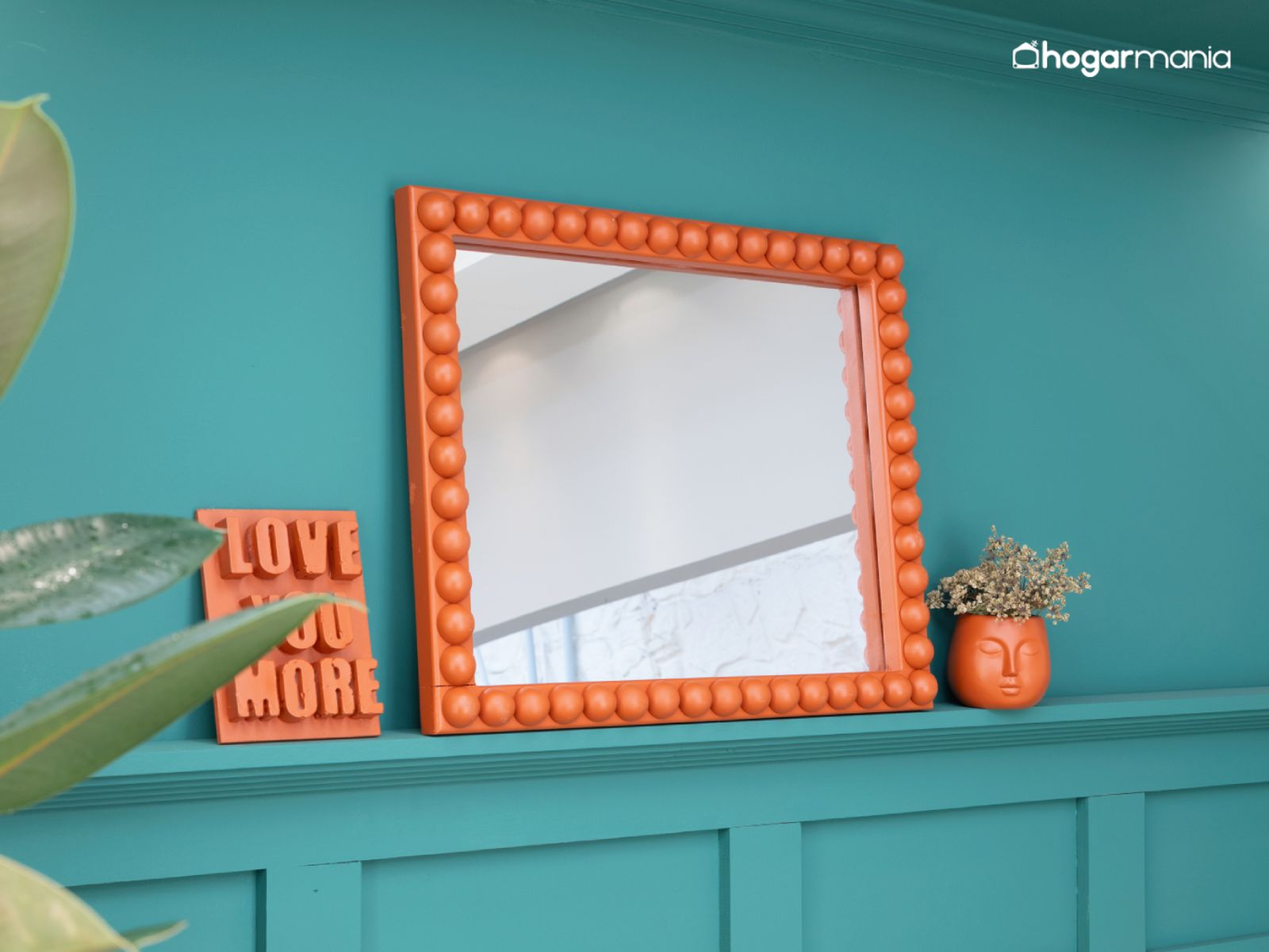 El marco terminado, decorado con medias esferas de madera y pintado en color caldera, aporta un contraste vibrante sobre la pared verde.