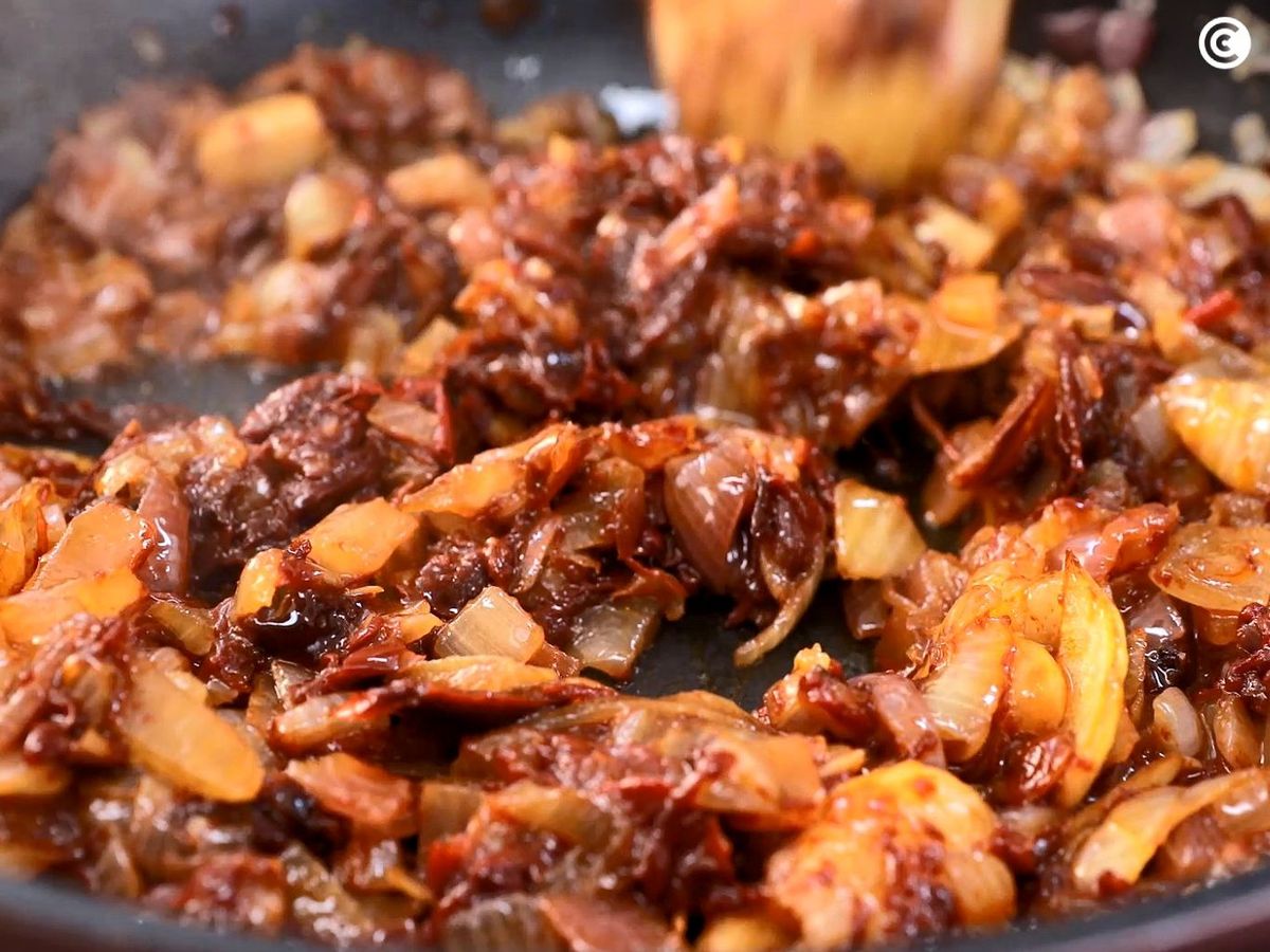 Añadir la pulpa del pimiento choricero a la cebolla para hacer la salsa vizcaína