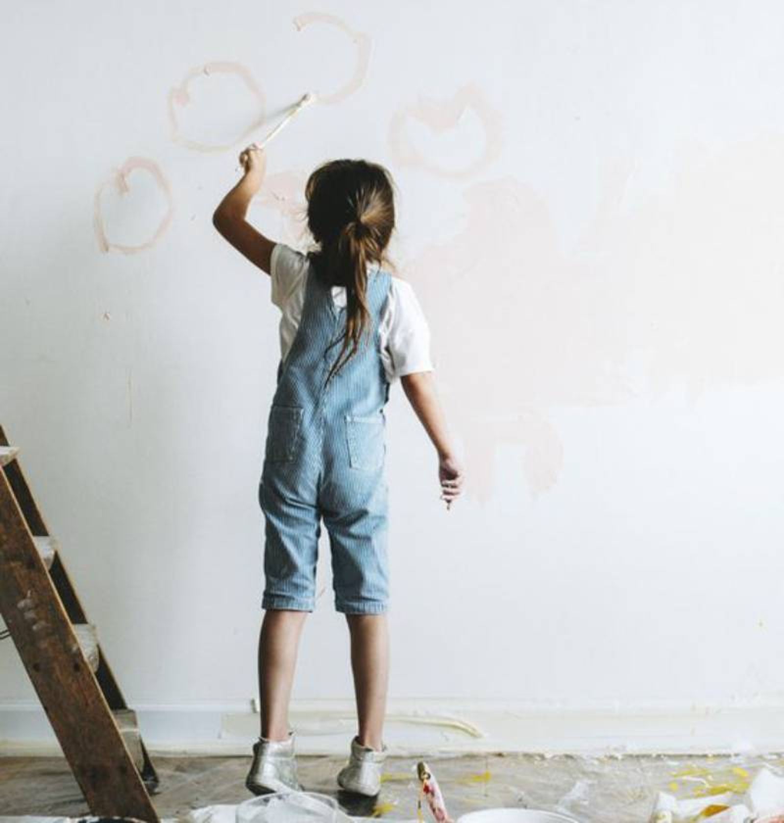 Niña pintando la pared de su dormitorio. Niña pintando la pared de su dormitorio.