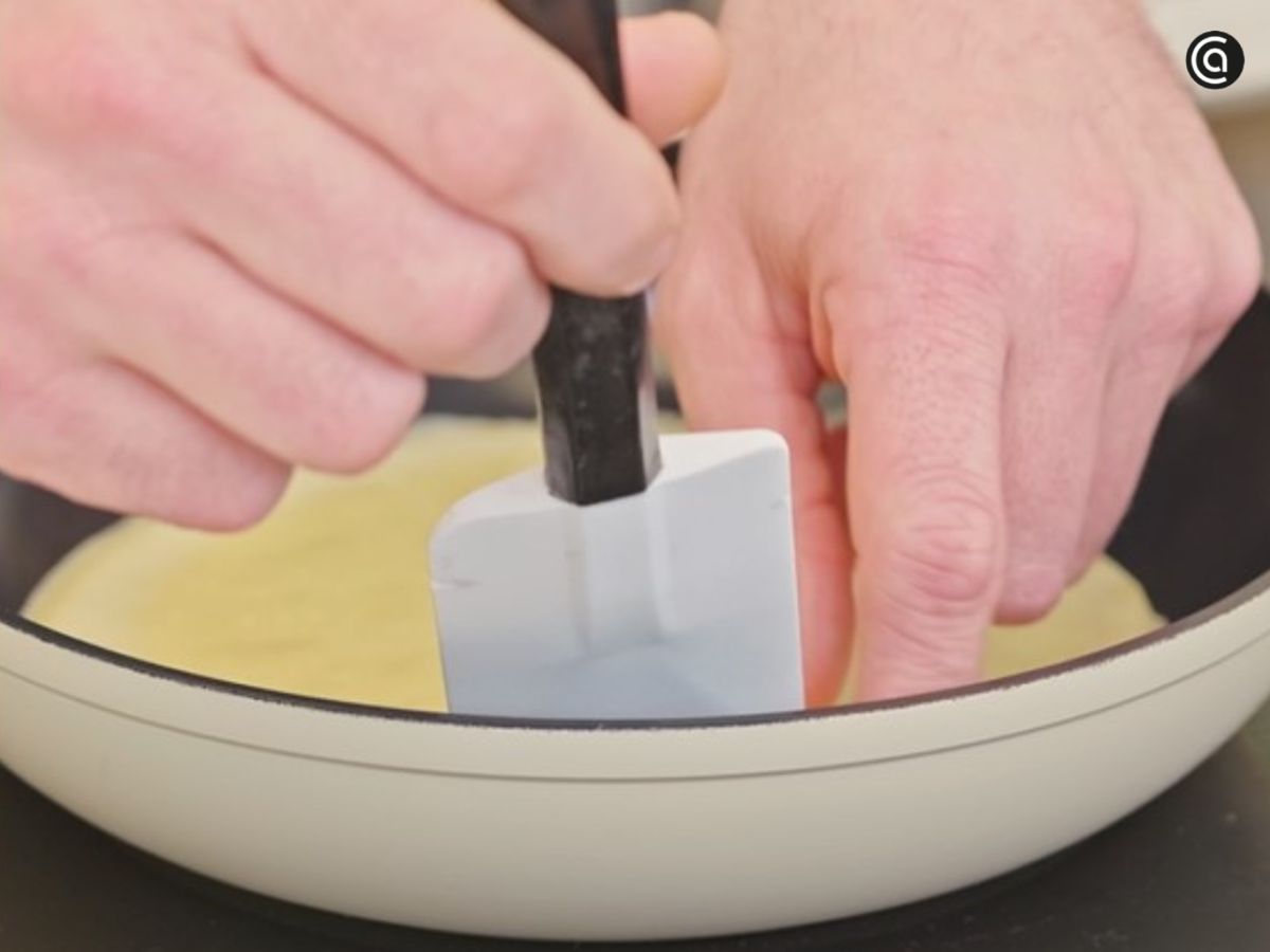 Con una espátula, se despega el frixuelo para darle la vuelta con cuidado.