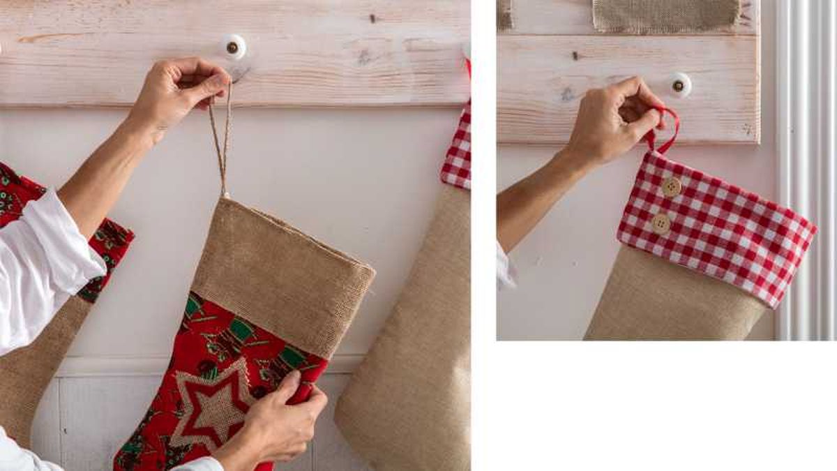 Manos de mujer colocando las botas en el perchero de Navidad.