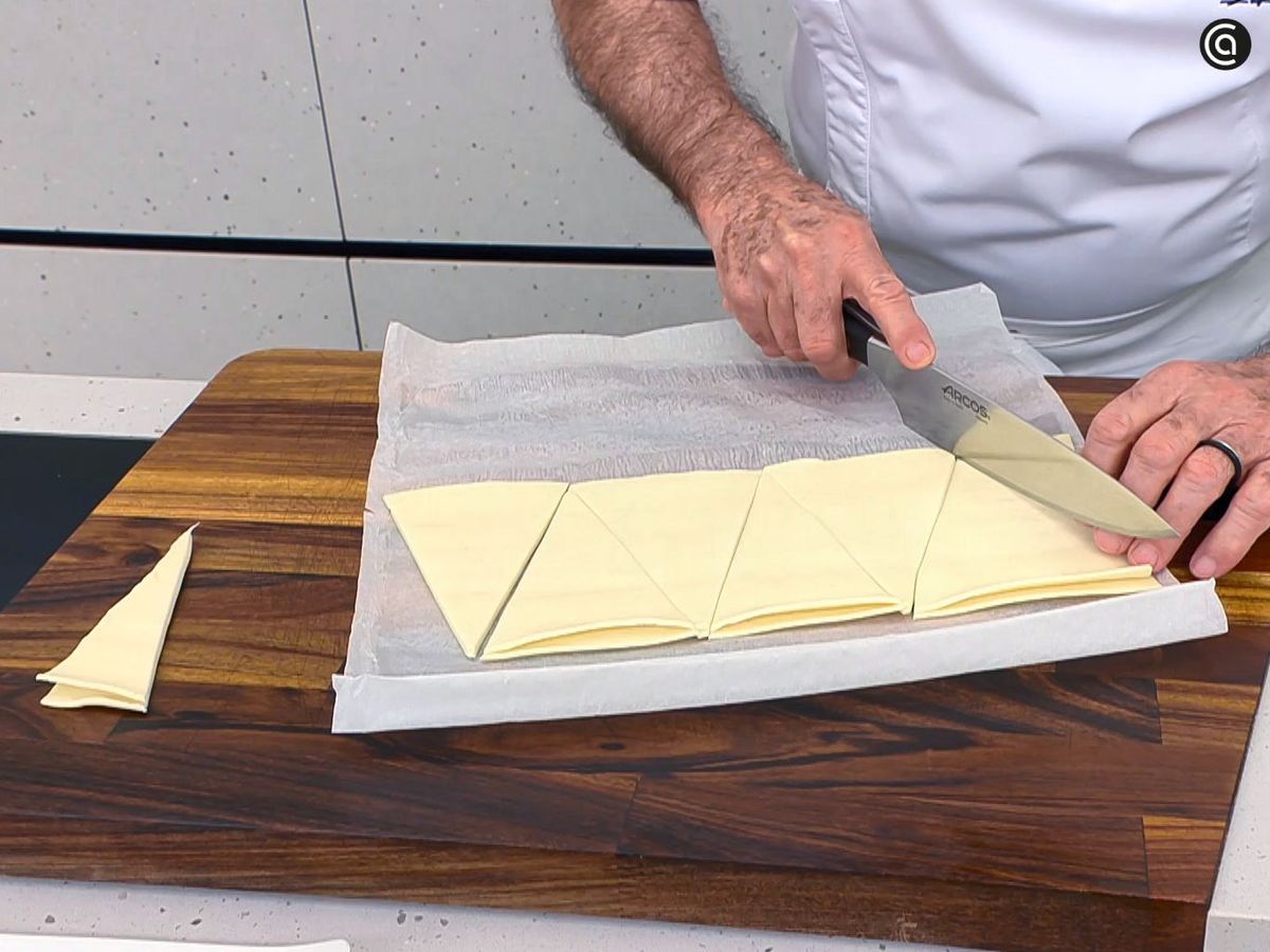 Corta el hojaldre en triángulos para hacer los mini cruasanes