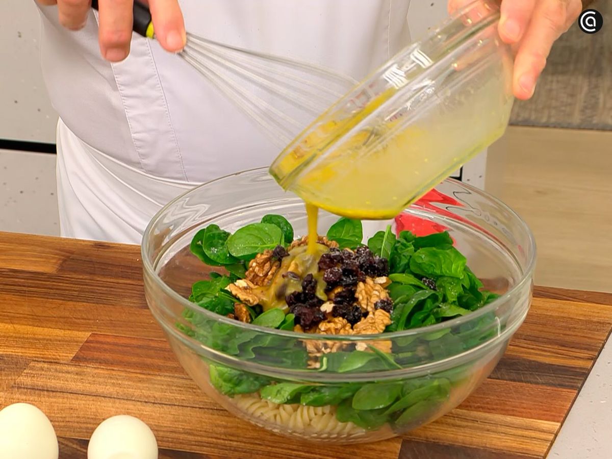 Mezcla las hojas de espinaca con nueces, arándanos y aliña con la vinagreta