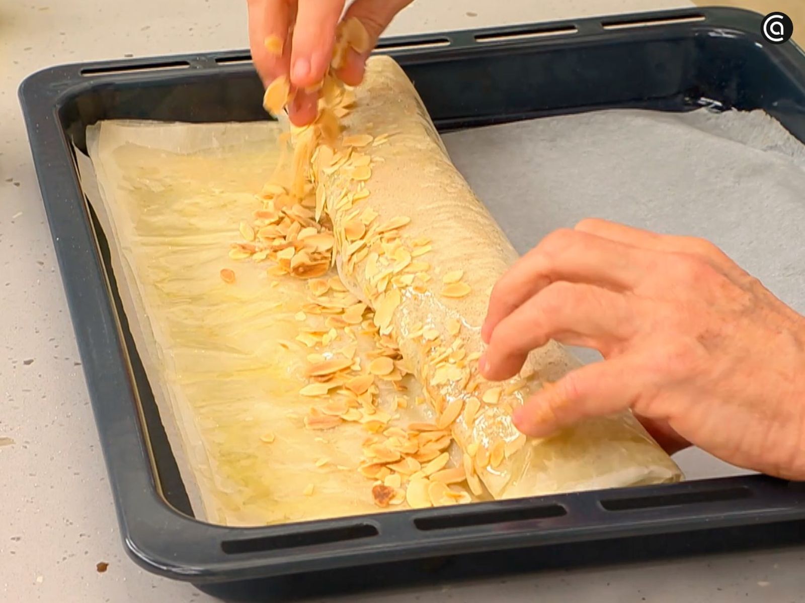 Enrolla la pasta filo con el relleno de pera y cubre con almendra laminada
