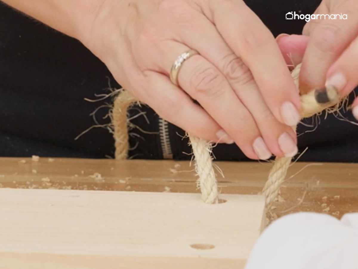 Pasamos los extremos de la cuerda por los orificios y los aseguramos con nudos firmes.