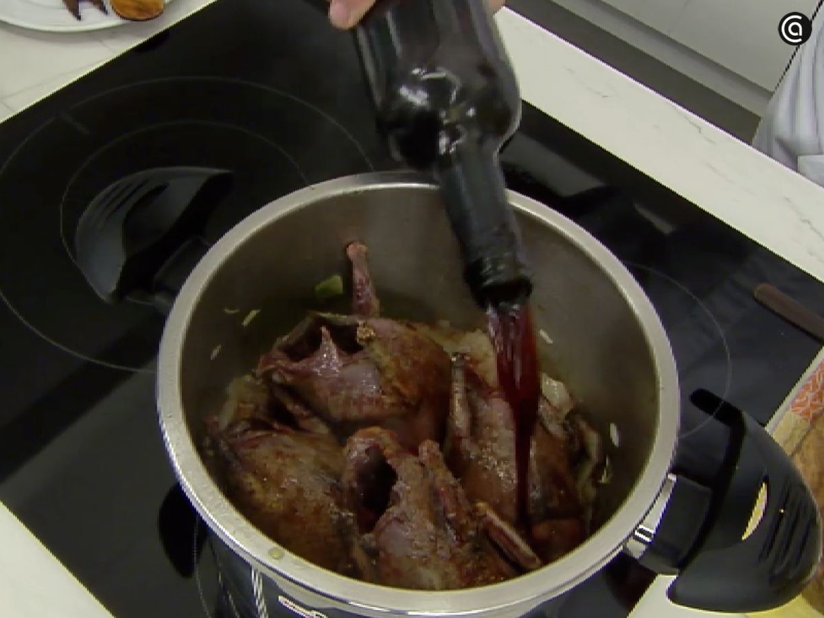 Agrega las palomas y el vino a la cazuela con las verduras y el brandy flambeado