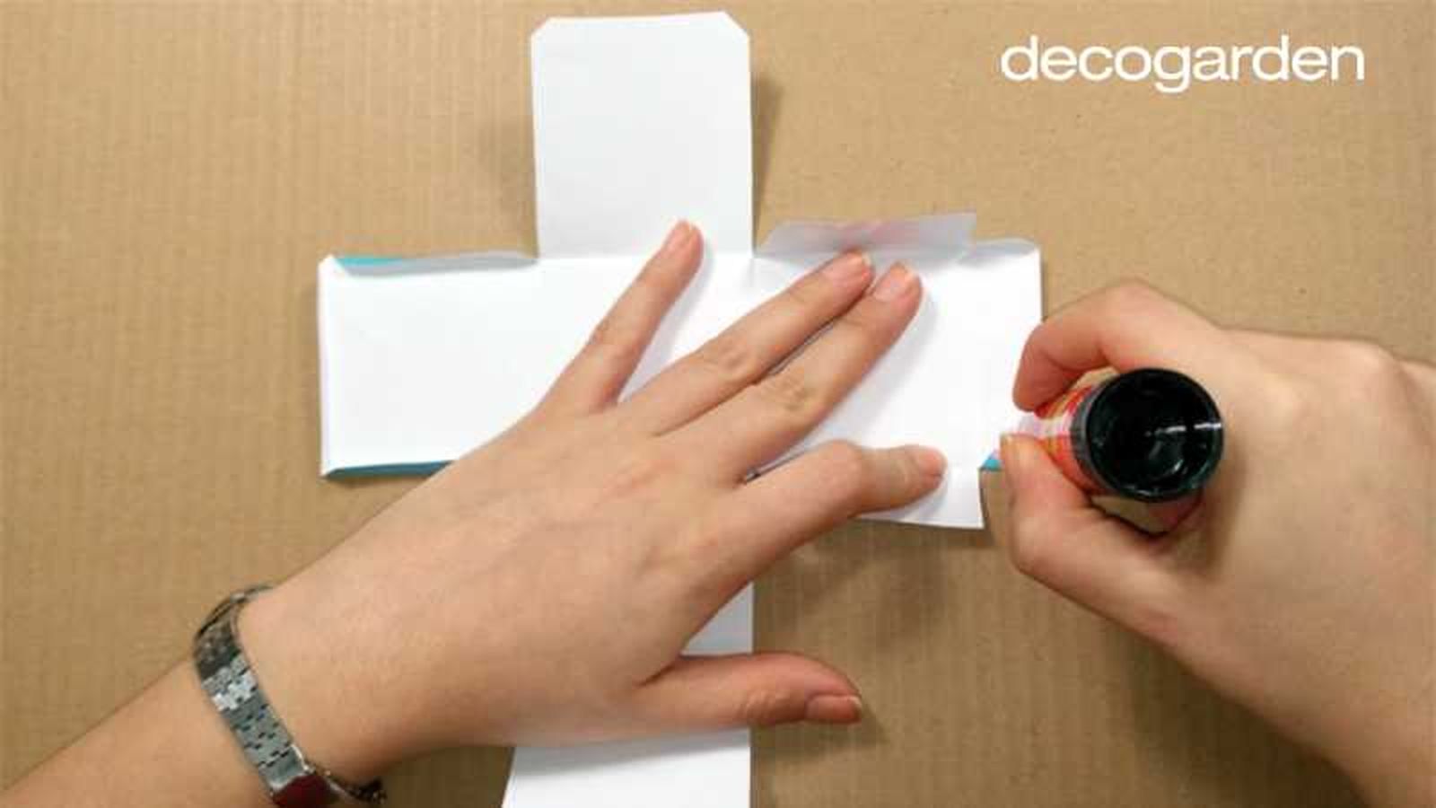 Doblar las pestañas de la caja de papel.