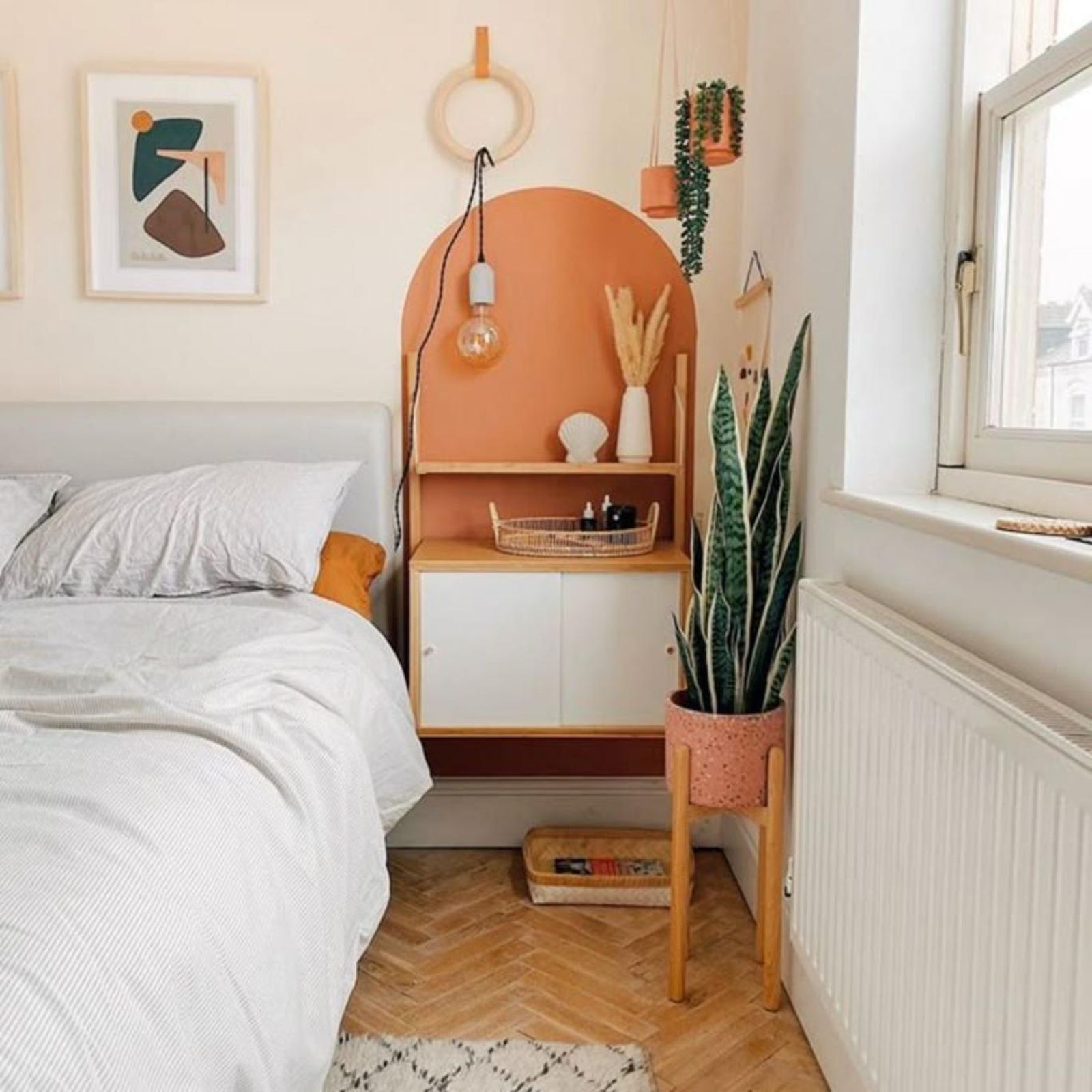 Dormitorio con suelo y muebles de madera y arco naranja en la pared. Dormitorio con suelo y muebles de madera y arco naranja en la pared.