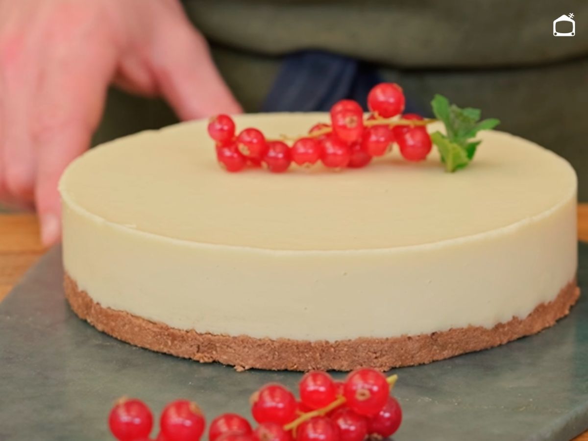 Desmolda y decora con grosellas la tarta de chocolate blanco
