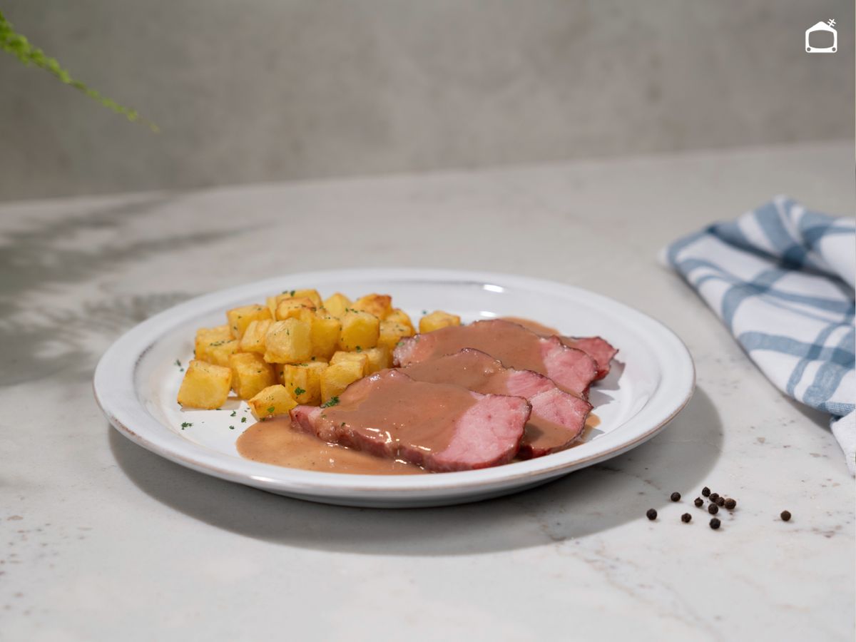 Un asado jugoso con salsa casera y patatas fritas para acompañar.