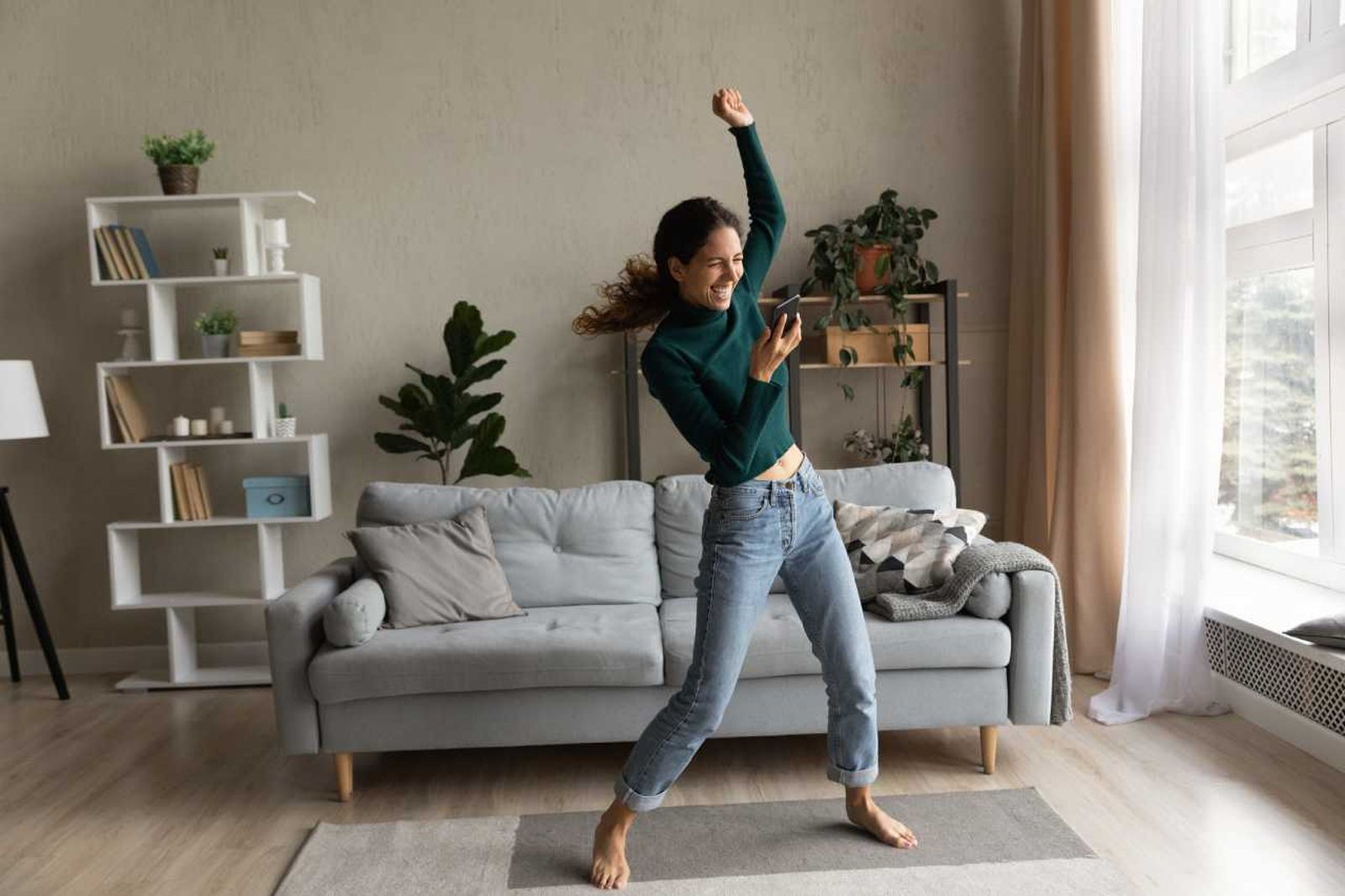 Mujer bailando en un hogar lleno de energía positiva.