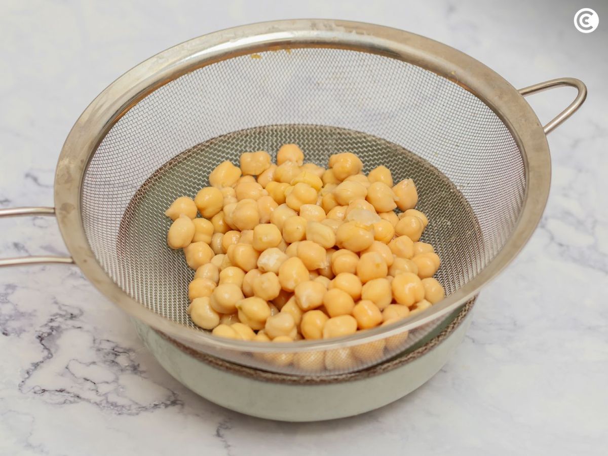 Escurrir los garbanzos cocidos para hacer hummus de pimiento