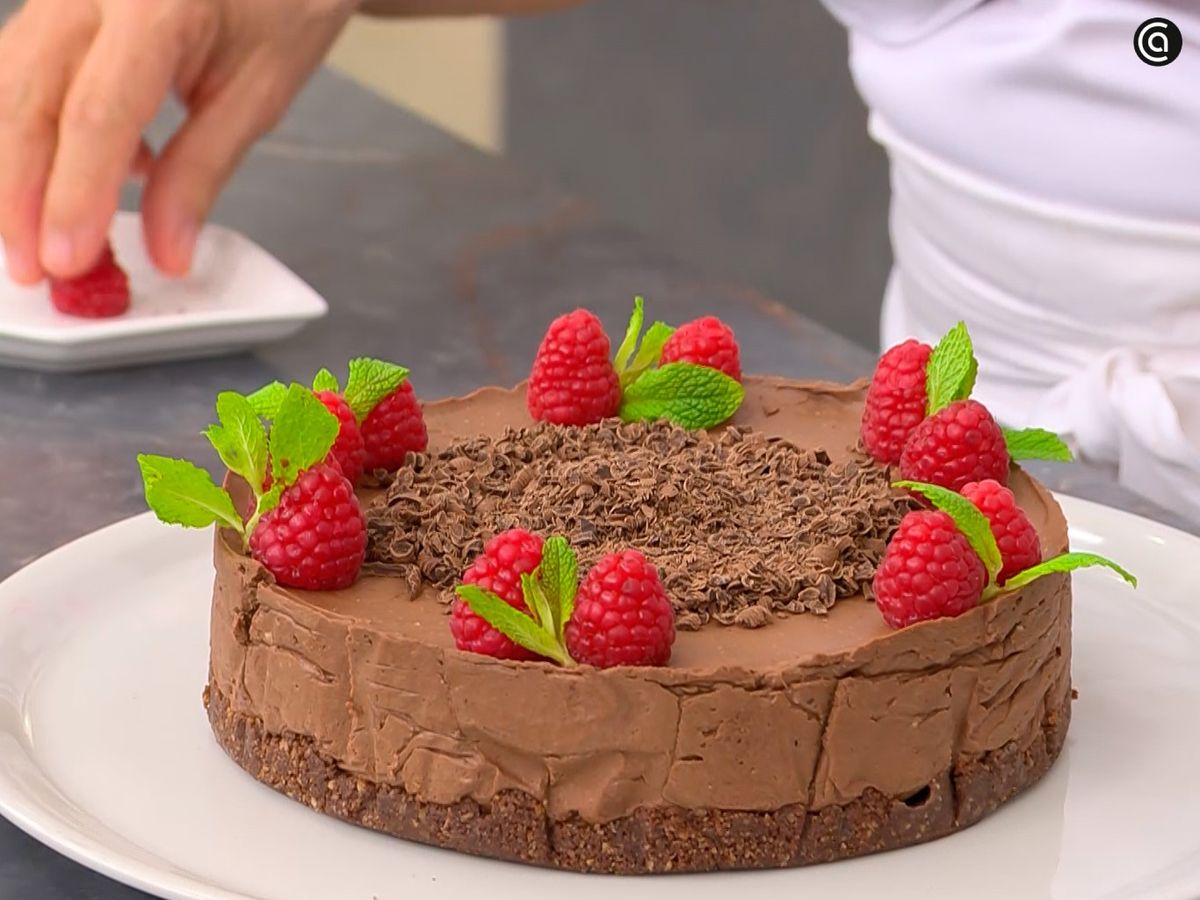 Desmolda la tarta y decórala con chocolate, frambuesas y menta