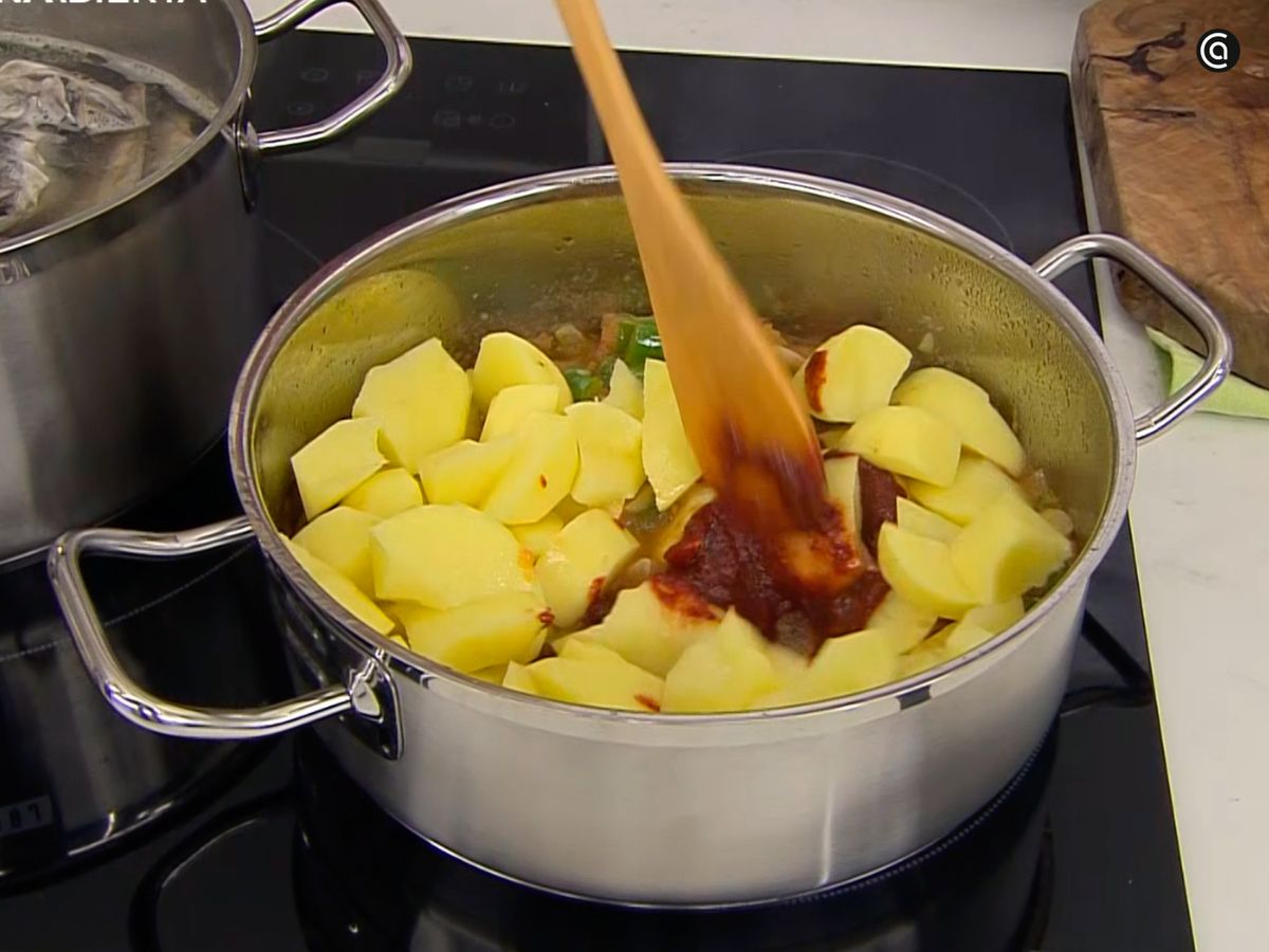 Añade las patatas y la pulpa de pimiento choricero a las verduras