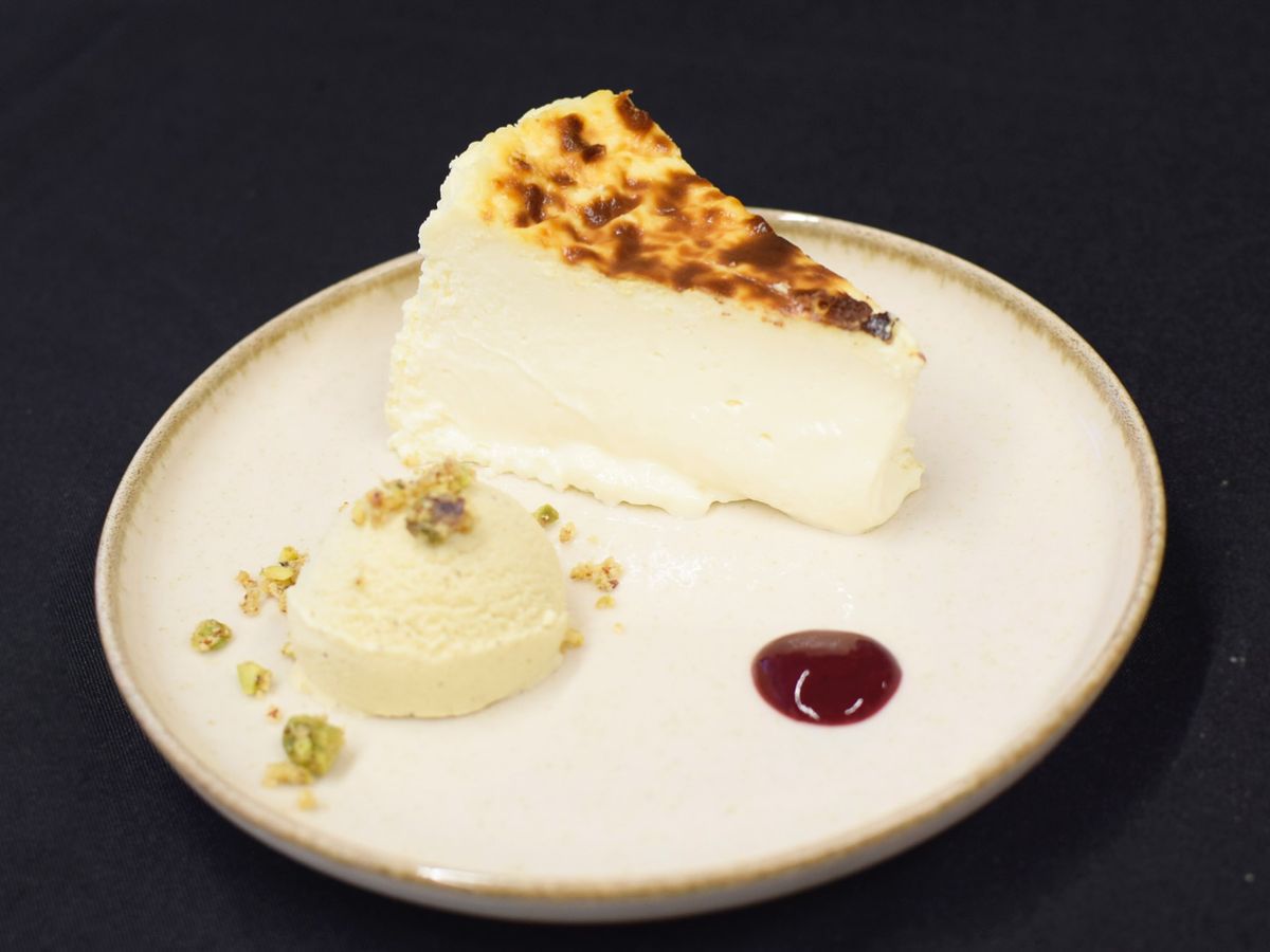 La segunda mejor tarta de queso de Madrid 2025, del obrador Maritta, se acompaña de helado de pistacho, crumble y compota de frutos rojos.