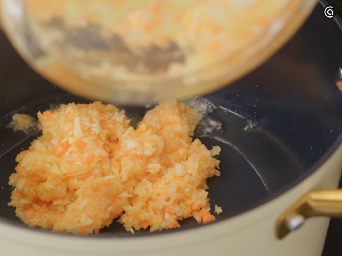 Cebolleta, puerro y zanahoria pochadas a fuego suave para crear la base del caldo.