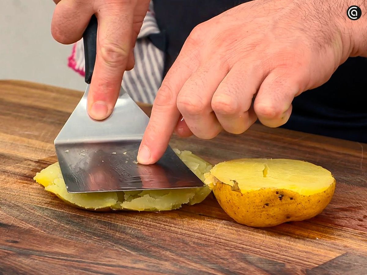 Aplasta las patatas asadas para servir junto con el chili y la crema