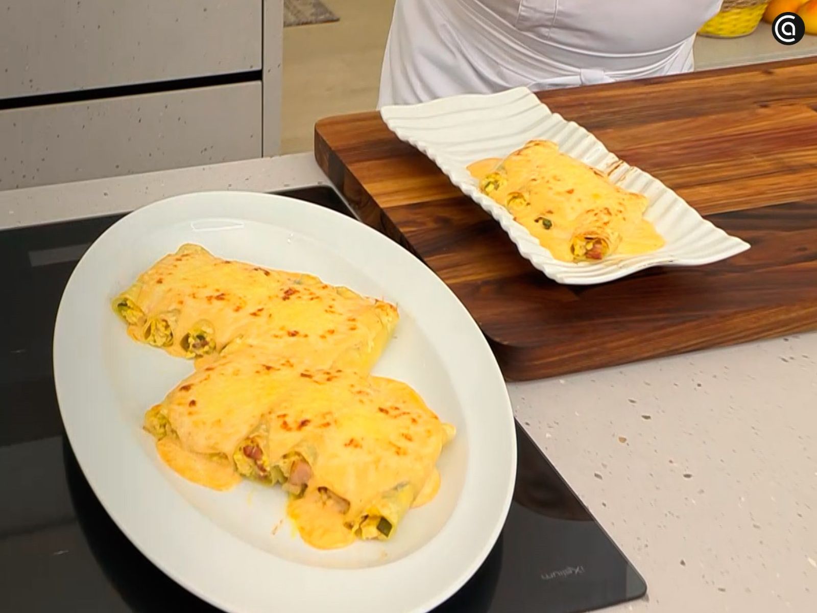 Sirve los canelones rellenos de pollo, panceta y calabacín Sirve los canelones rellenos de pollo, panceta y calabacín