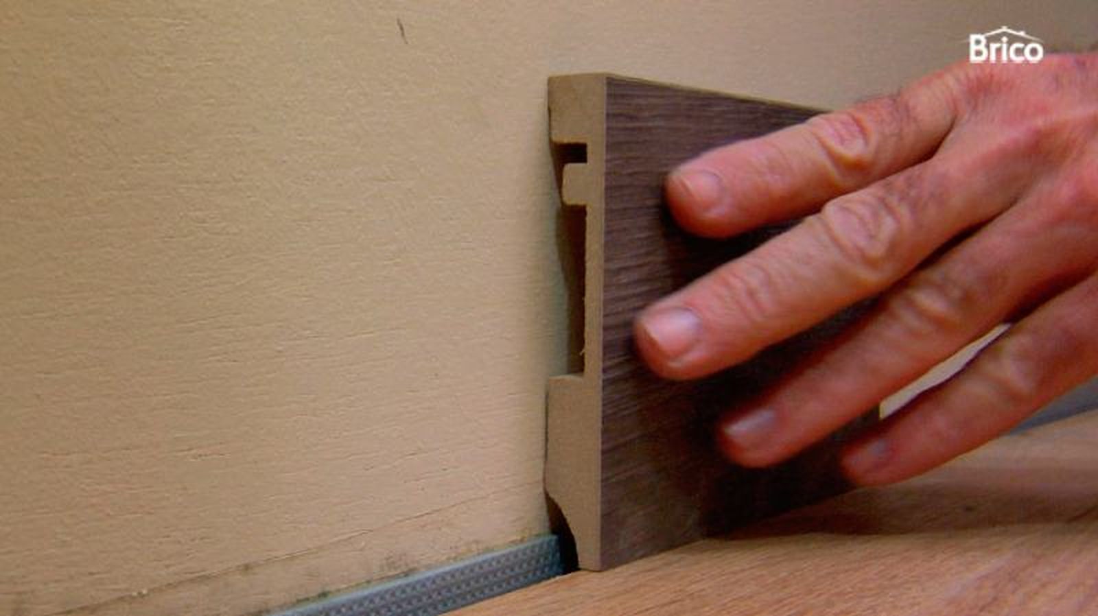 Persona instalando un rodapié de MDF Persona instalando un rodapié de MDF