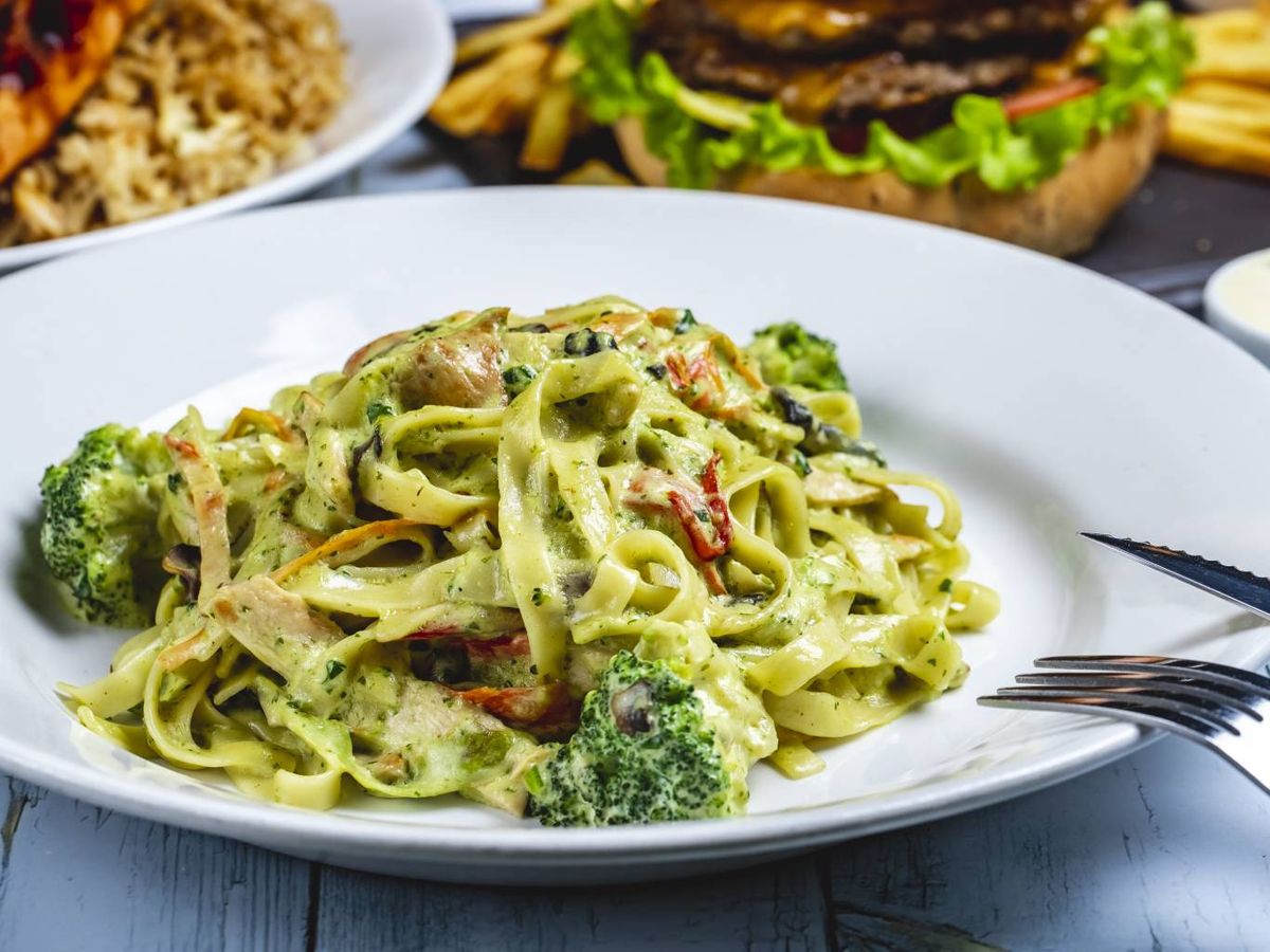 Plato de fettuccine con salsa cremosa, brócoli y pollo: una combinación ideal para pastas largas que retienen bien las salsas densas.