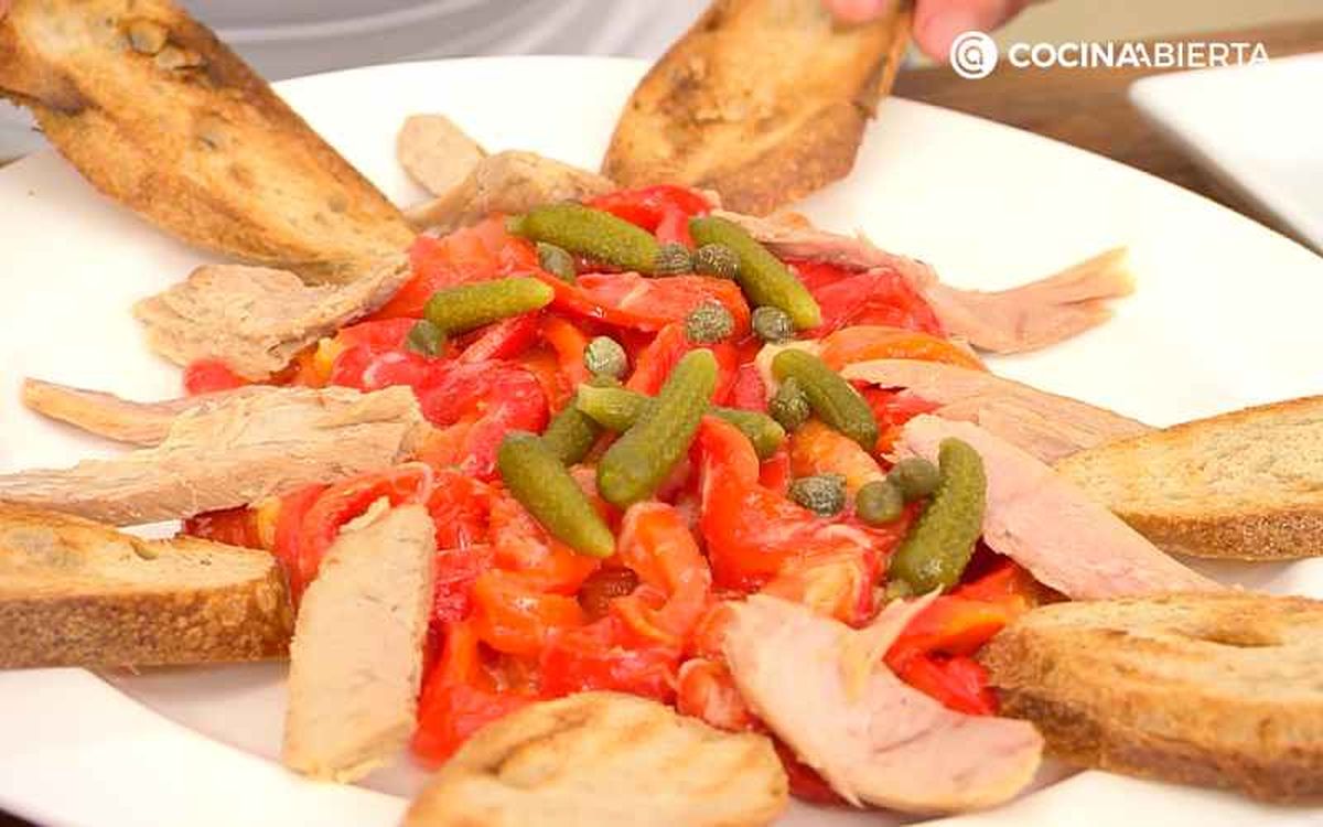 Sirve la ensalada de pimientos morrones con ventresca y acompaña con pan tostado