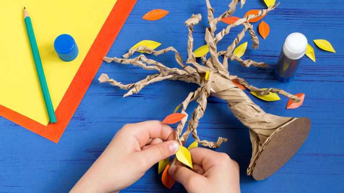 Paso 5 para hacer el árbol de cartón, pegar las hojas.