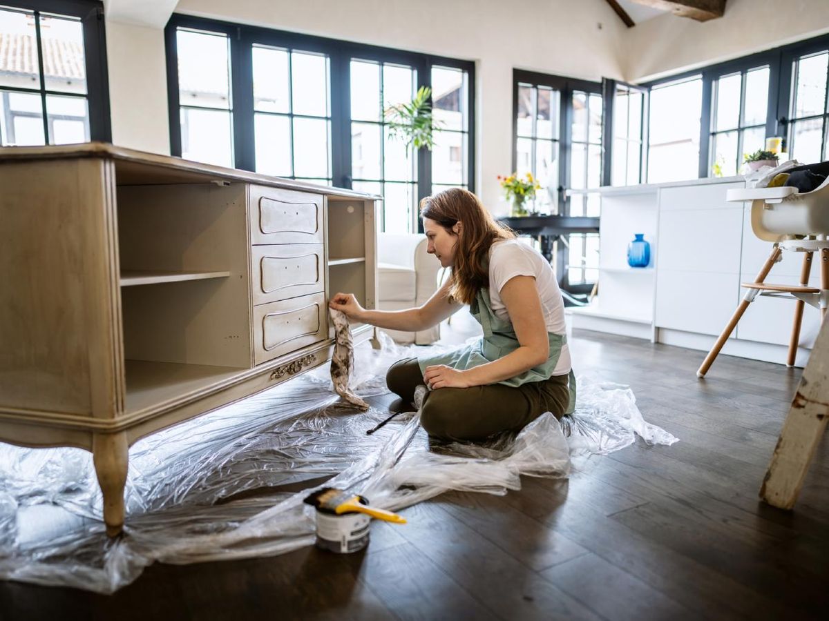 Mujer restaurando un mueble antiguo.