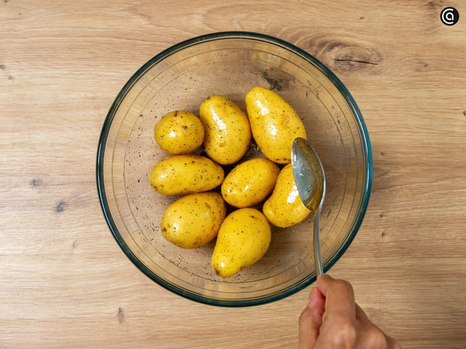 Mezcla las patatas con aceite de oliva virgen, sal y pimienta en el bol