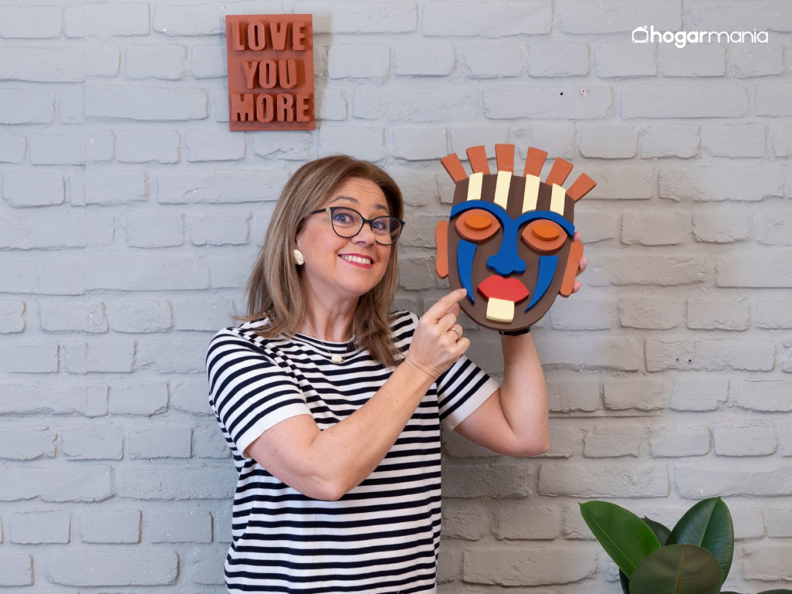 Una máscara decorativa hecha en madera que demuestra cómo el juego de formas y colores transforma una pared neutra.