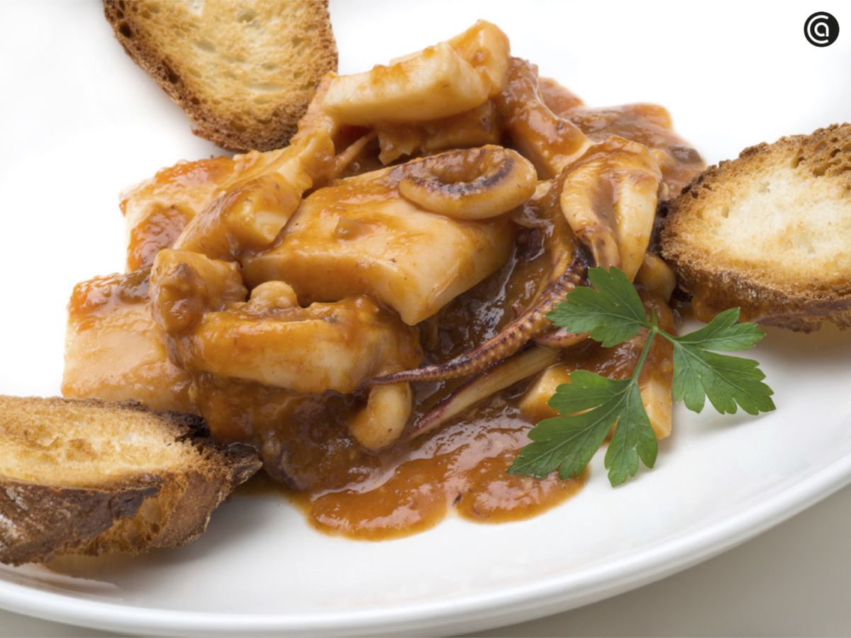 Sirve los calamares en salsa de tomate con el pan tostado