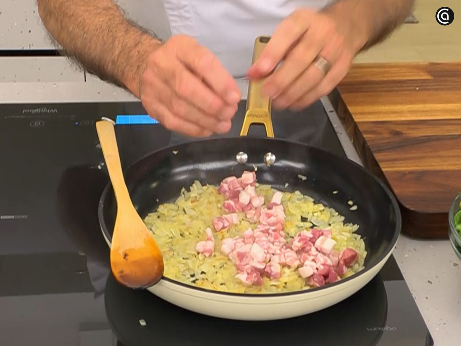 Pocha la cebolla y añade la panceta en dados para que se dore.