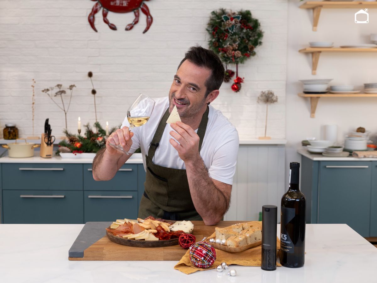 Joseba Arguiñano brinda con una tabla ya lista, un buen queso en mano y el vino recién abierto, perfecto para arrancar un picoteo festivo.