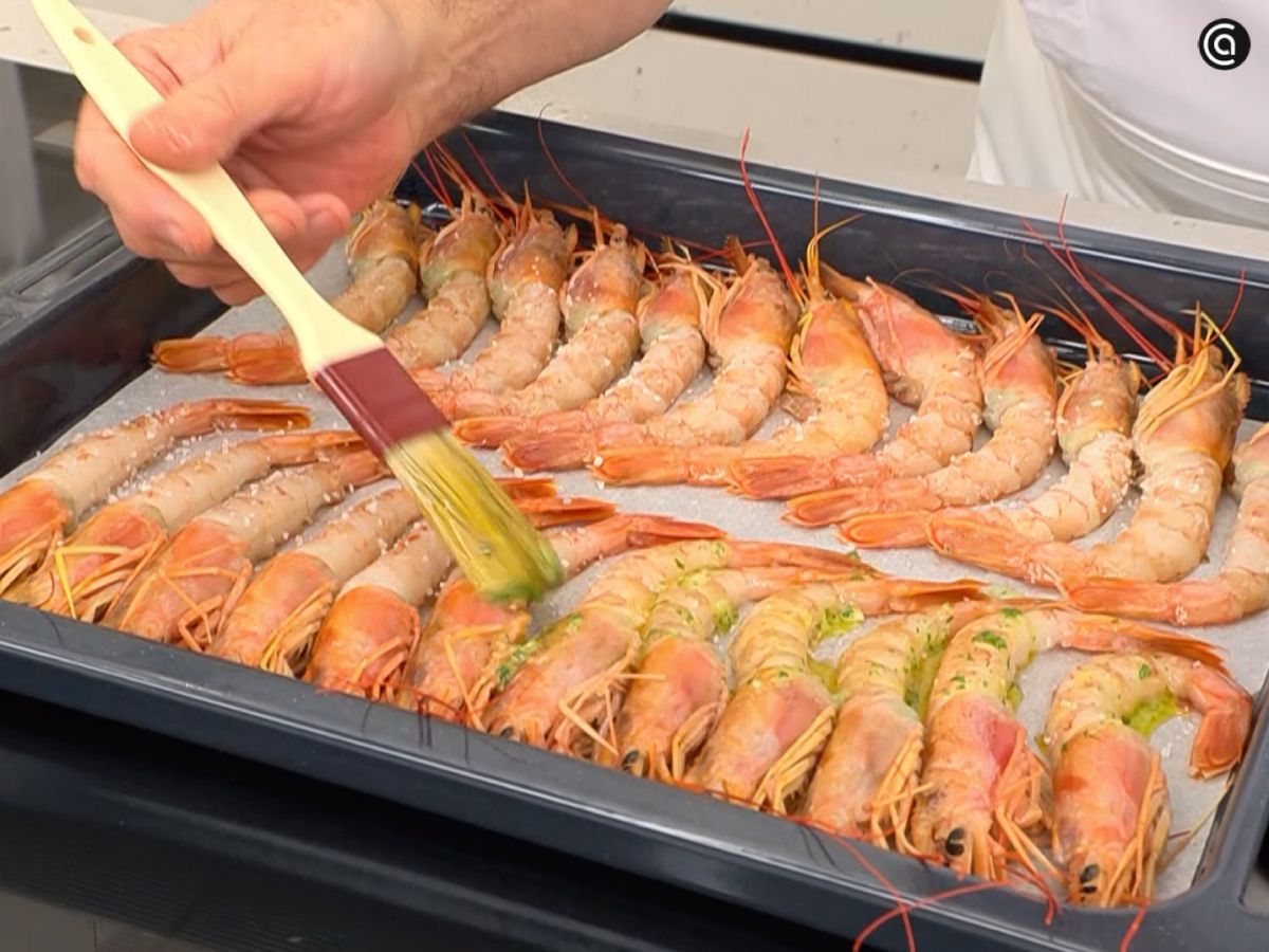 Los gambones se disponen en la bandeja y se cubren con el majado para que queden jugosos y aromáticos.