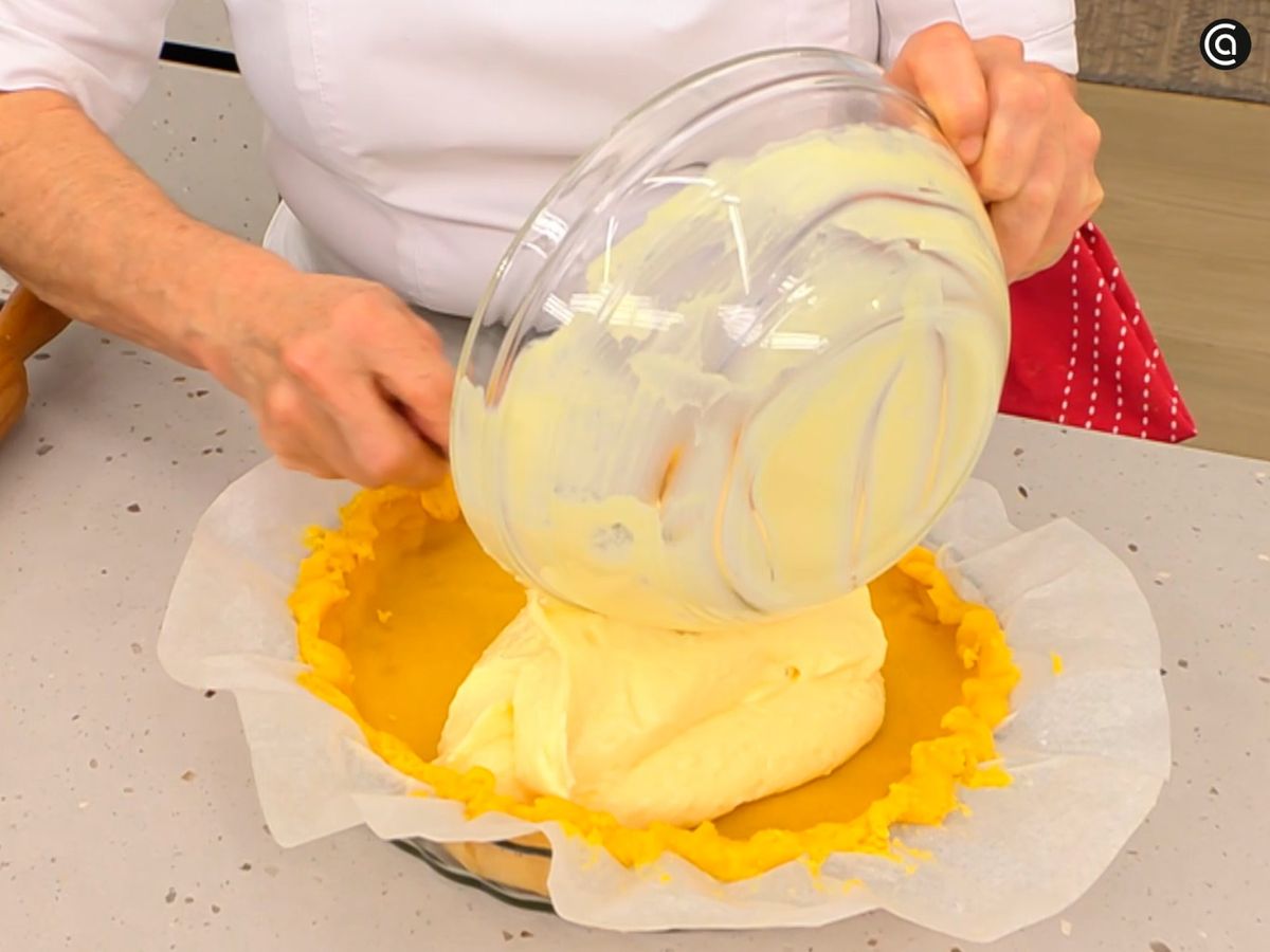 Estira la masa, colócala sobre la base del molde y vierte la crema pastelera