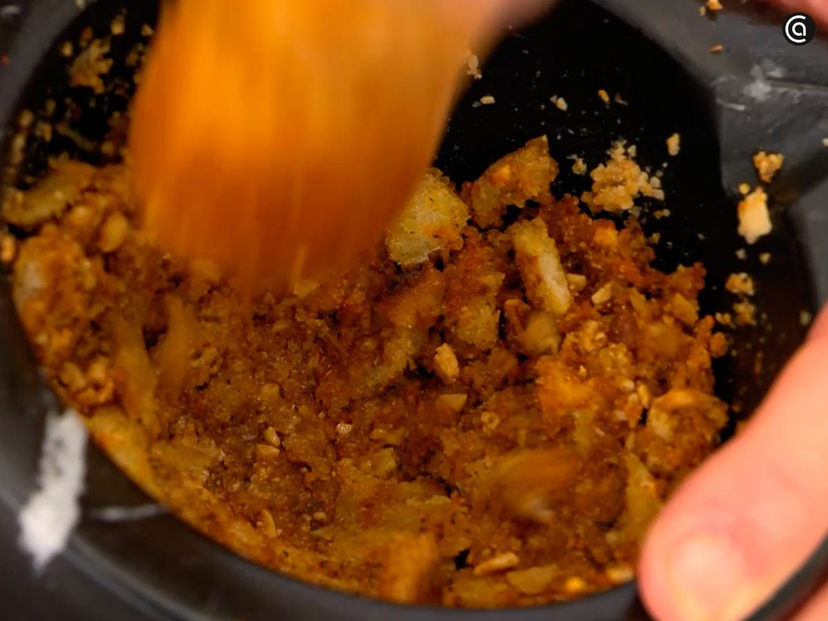 Machaca en el mortero el pan frito junto con las almendras, el ajo y las especias