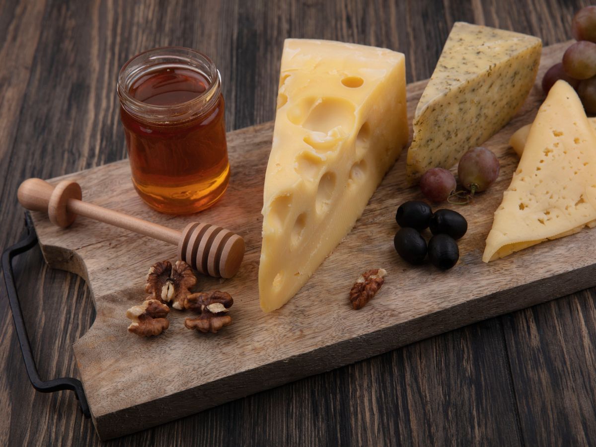 Quesos curados y semicurados con nueces, uvas y miel: contraste de sabores dulces y salados para una experiencia gourmet.