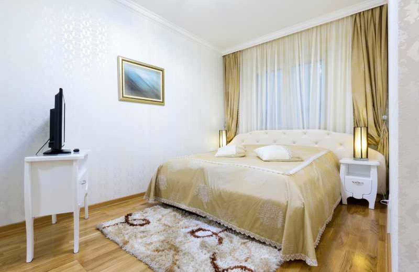 Dormitorio pequeño con cortinas finas en dorado. Dormitorio pequeño con cortinas finas en dorado.