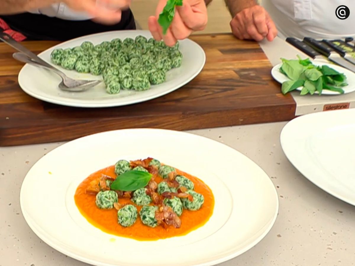 Sirve los malfatti de espinacas y ricota con hojas de albahaca