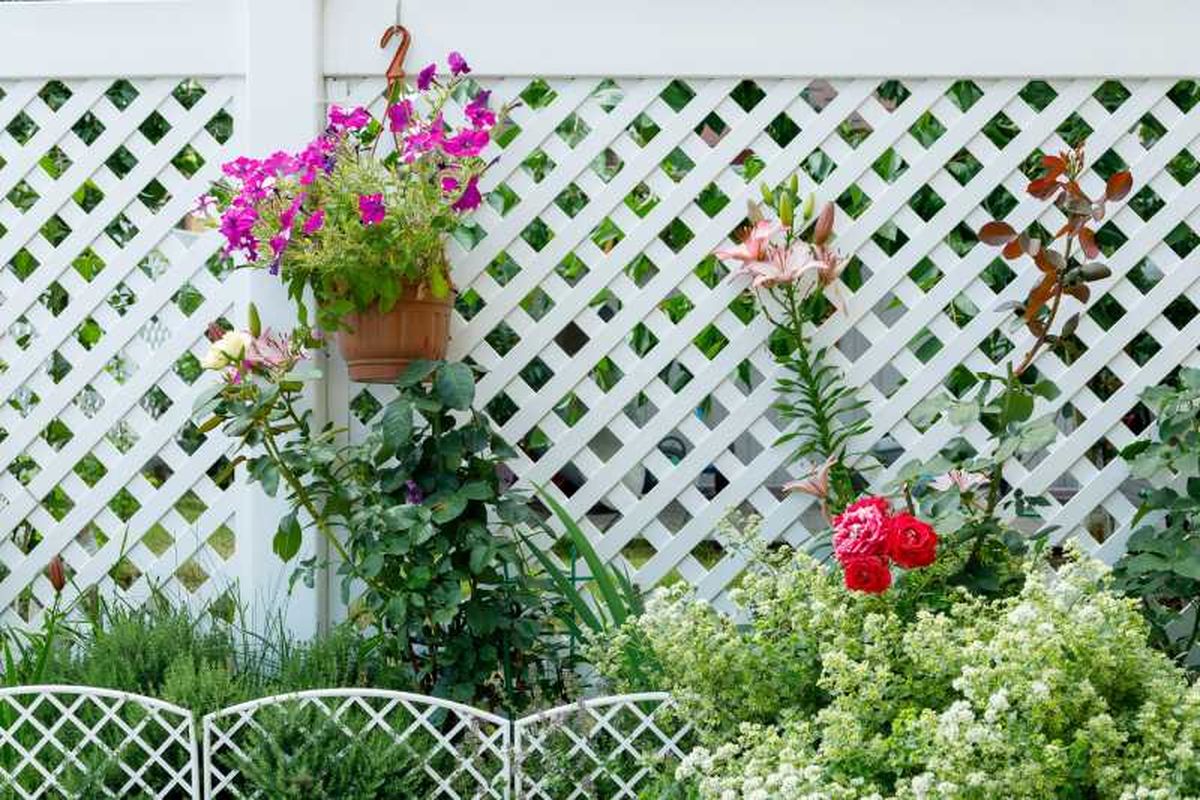 Celosía blanca tradicional decorada con flores.