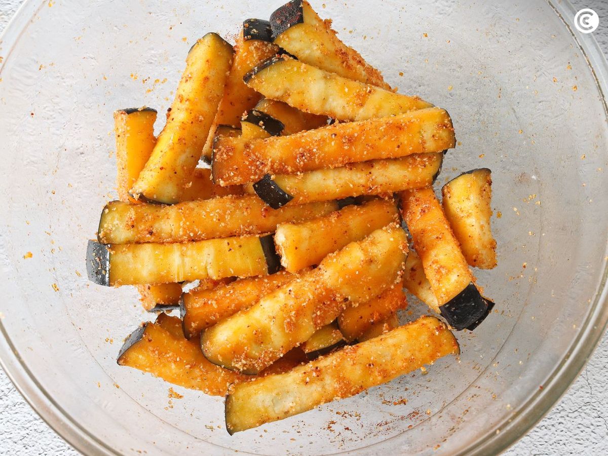 Añadir especias a las berenjenas para hacer en freidora de aire