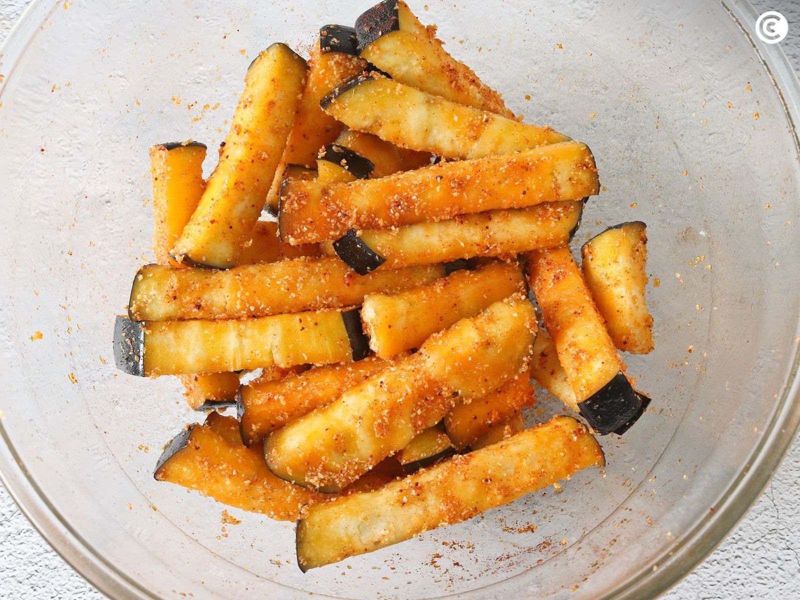 Añadir especias a las berenjenas para hacer en freidora de aire