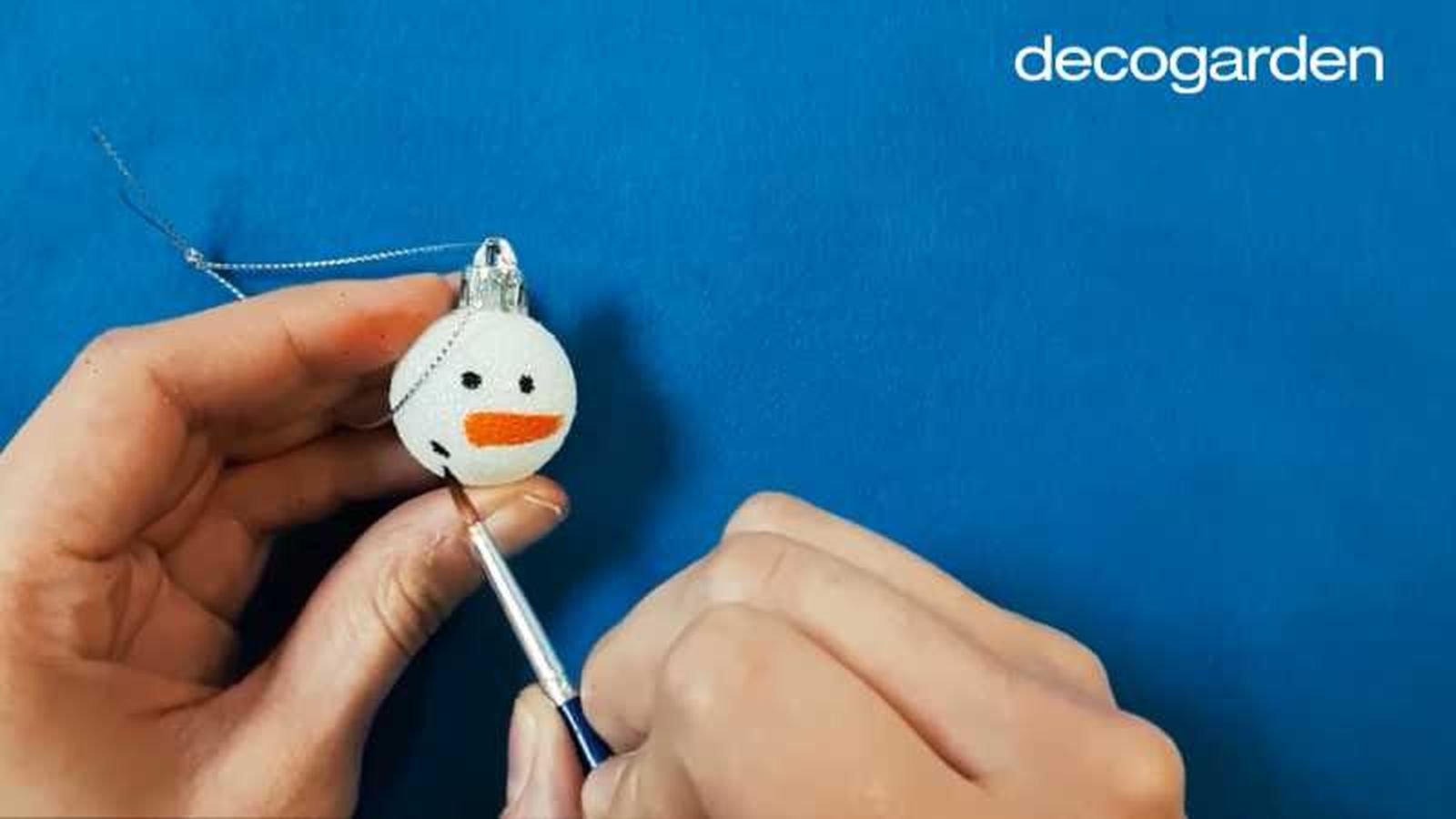 Pintar un muñeco de nieve en una bola de Navidad. Pintar un muñeco de nieve en una bola de Navidad.